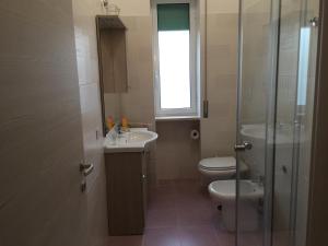 a bathroom with a toilet and a sink and a shower at Diamante in Sorrento +3 photos