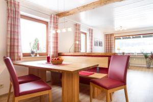 a kitchen with a wooden table and two chairs at Ferienwohnungen Alpentraum - freiSicht in Fischen +18 photos