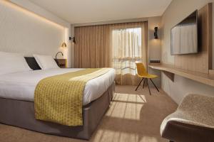 a hotel room with a bed and a window at Auteuil Tour Eiffel in Paris