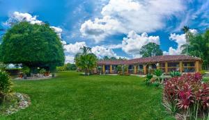 a house with a large yard in front of it at Finca Hotel La Negrita in Montenegro