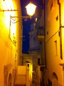 an alley with a street light and a clock tower at night at Hotel Yria in Vieste