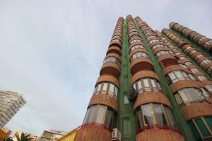 a green building with many windows on the side of it at coblanca 5 in Benidorm