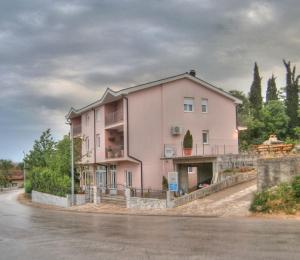 una casa rosa al lado de una carretera en Villa Petra, en Međugorje