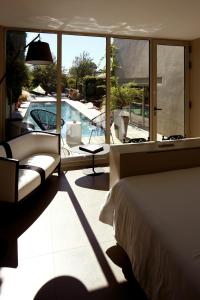 a bedroom with a bed and a view of a swimming pool at Auberge Du Paradis in Saint-Amour-Bellevue