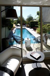 een woonkamer met uitzicht op een zwembad bij Auberge Du Paradis in Saint-Amour-Bellevue