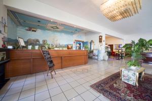 a lobby with a restaurant with a sign on the wall at Hotel Elefante Bianco in Crespellano