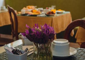 a vase of purple flowers sitting on a table at Império do Rei Boutique Hotel in Castelo Branco