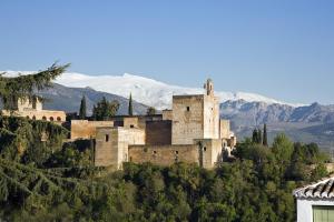 a castle on a hill with mountains in the background at Apartamento Paseo del Salón in Granada
