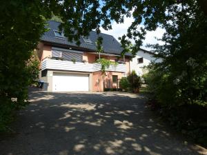 una casa con una puerta de garaje blanca y un camino de entrada en Oerlihome, en Oerlinghausen