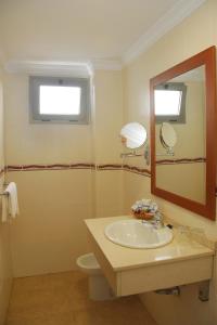 ein Badezimmer mit Waschbecken, Spiegel und Toilette in der Unterkunft Hotel Pujol in Las Palmas de Gran Canaria