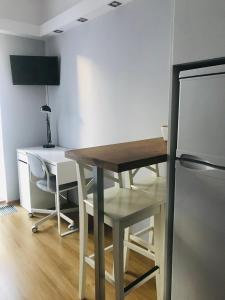 a kitchen with a wooden table and a refrigerator at Apt Pawia in Warsaw