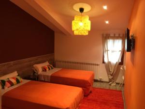 1 dormitorio con 2 camas y lámpara de araña en Turó de la Torre en Manresa