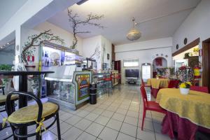 a restaurant with a dining area with tables and chairs at Hotel Elefante Bianco in Crespellano