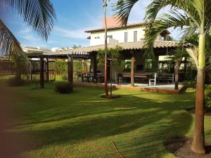 una casa con palmeras frente a un patio en Maravilhosa casa de praia, en Aracaju