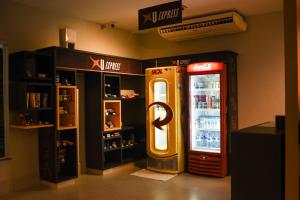 Uiramutam Palace Hotel في بوا فيستا: آلة كولا كوكا بجوار مبرد للمشروبات
