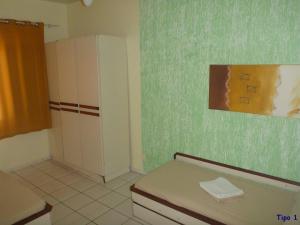 a small bathroom with a bed and a cabinet at Pousada Ilhas Gregas in Florianópolis