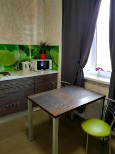 a table and chairs in a kitchen with a microwave at Стильные аппартаменты на Новых Домах in Kharkiv