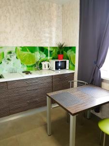 a kitchen with a counter with a microwave and a table at Стильные аппартаменты на Новых Домах in Kharkiv