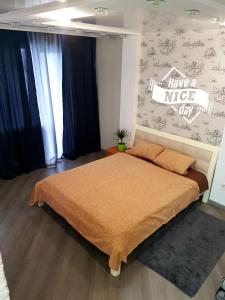 a bedroom with a large bed with a sign on the wall at Стильные аппартаменты на Новых Домах in Kharkiv