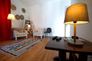 a living room with a table and a lamp at Eskama hostel in Esposende