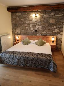a bedroom with a bed with a stone wall at Domačija Linč in Rodik