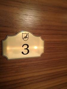 una etiqueta con el número tres en un suelo de madera en Domačija Linč en Rodik