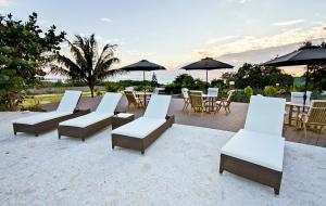 a row of beach chairs sitting on top of a sandy beach at El Morro Eco Adventure Hotel in San Fernando de Monte Cristi