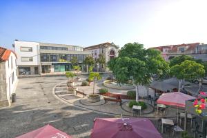 un patio con mesas y sombrillas en una ciudad en Eskama hostel, en Esposende