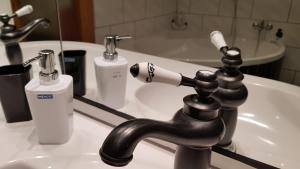 a bathroom sink with a black faucet and a mirror at Ferienwohnung-Kormann in Schkopau