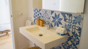 a bathroom with a sink and blue and white tiles at Casa Gema in El Port de la Selva