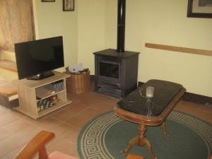 a living room with a television and a fireplace at Cal Batistet Ferrer in Torroja