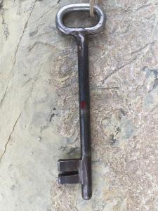 una llave metálica sentada en un suelo de piedra en Cal Batistet Ferrer, en Torroja