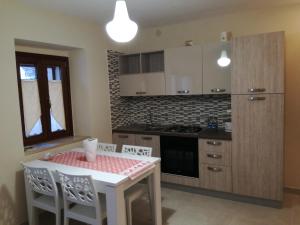 a kitchen with a white table and chairs and a stove at Dormire nel Borgo in Bovino