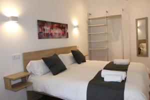 a bedroom with two beds with white sheets and black pillows at Apartamentos La Luna in La Solana