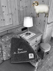 ein Schlafzimmer mit einem Bett und einer Lampe und einem Schaf auf dem Tisch in der Unterkunft Haus St. Korbinian in Mittenwald