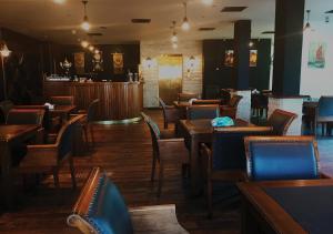 un restaurante con mesas y sillas de madera y un bar en Ajnadeen Hotel, en Irbid