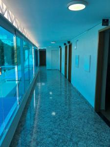 un couloir vide dans un immeuble de bureaux avec des plafonds bleus dans l'établissement Hotel Butantã, à São Paulo