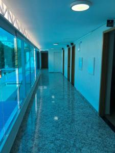 an empty hallway in an office building with blue ceilings at Hotel Butantã in Sao Paulo