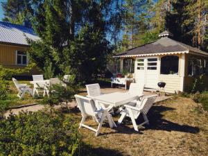 a picnic table and chairs in a yard with a gazebo at Miekkalan aitat in Lappeenranta