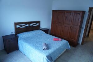 ein Schlafzimmer mit einem Bett und einem Holzschrank in der Unterkunft APARTAMENTO PTO LAJAS VISTAS AL MAR in Puerto de las Lajas