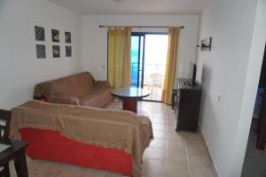 ein Wohnzimmer mit Sofa und Tisch in der Unterkunft APARTAMENTO PTO LAJAS VISTAS AL MAR in Puerto de las Lajas