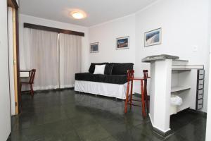 a bedroom with a bed and a table in it at Flat Itararé Tower Beach in São Vicente