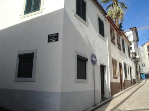 un edificio blanco con un letrero al lado de una calle en Violeta House en Funchal