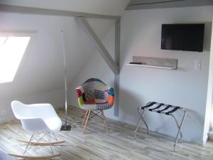a room with two chairs and a tv on a wall at C' 1 comble in Bischwihr