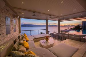 een woonkamer met banken en uitzicht op het water bij Moonstone - Samui's Premier Private Villa in Bangrak Beach