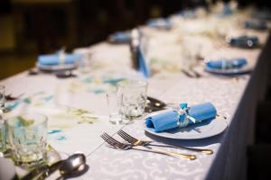 a table with a white table cloth with a blue napkin at Pokoje gościnne 30stka in Łęczna