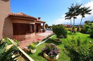 een huis met een tuin met bloemen en planten bij Alina - Vivienda vacacional con piscina privada in Puerto de la Cruz