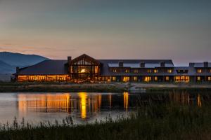 a large building with a reflection in the water at Sage Lodge in Pray