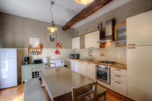 - une cuisine avec des placards blancs, une table et un réfrigérateur dans l'établissement La Casalamadonna, à Santa-Lucia-di-Moriani