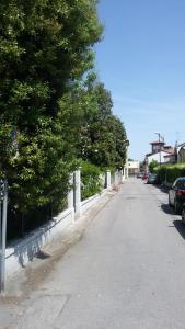 una calle vacía con árboles y una valla en Casa per Venezia&Treviso, en Treviso